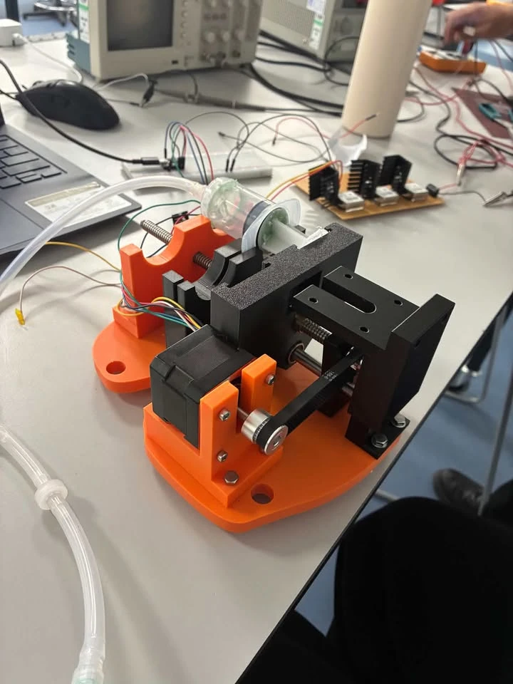 Printed orange and black fluidic actuation prototype on a laboratory bench.